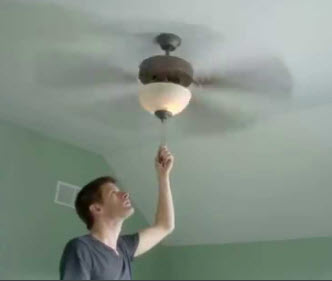 Man turning ceiling fan on